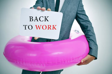 Man with a rubber ring around him, holding a back to work sign