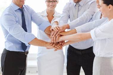 group of business professionals stacking hands