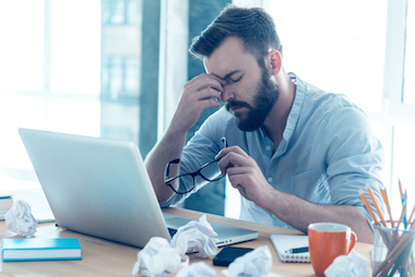 Man holding his hand to his head looking stressed