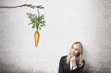 woman looking at carrot on the stick