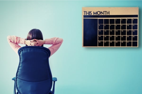 Woman on a chair staring at a blank calendar