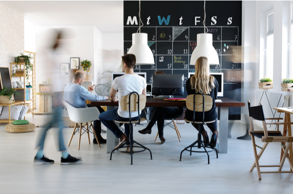 Employees sitting around their work desks