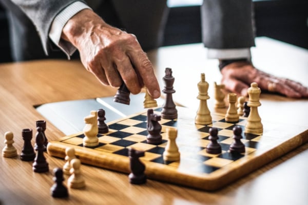 Man moving a piece on a chess board