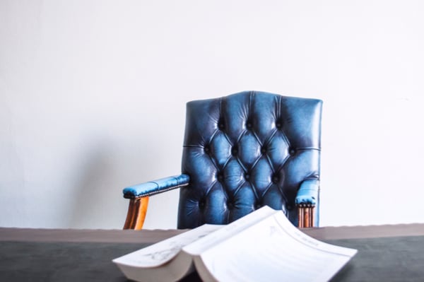 a book on a table with a leather chair behind it