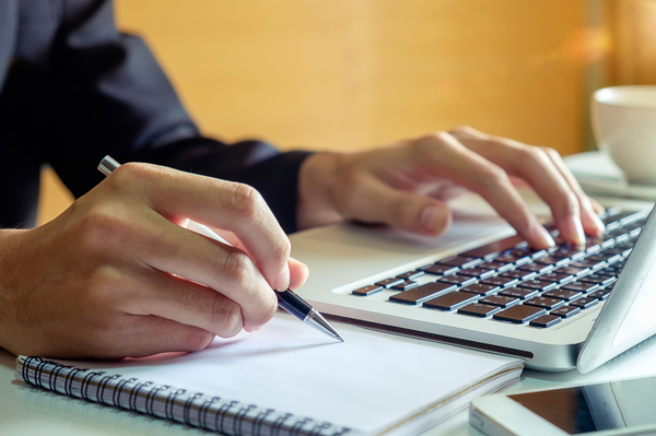 Man with laptop and notepad