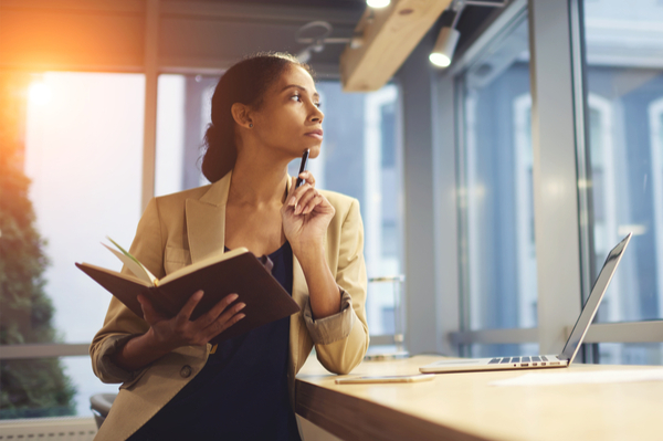 Woman with book open thinking