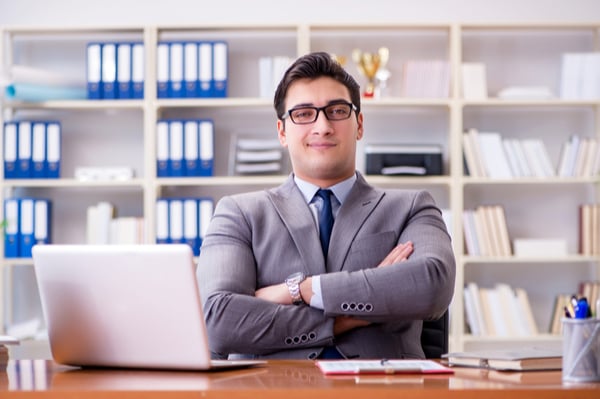 Man in suit sat with crossed arms