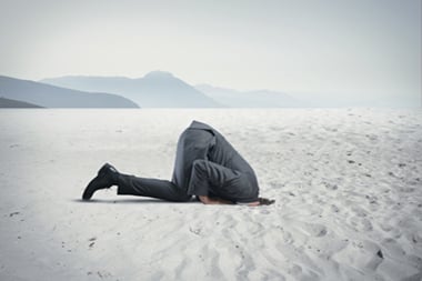 man with head hidden in the sand