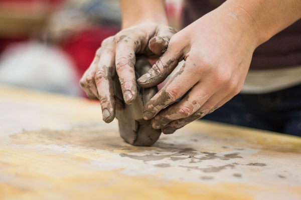 person rolling clay