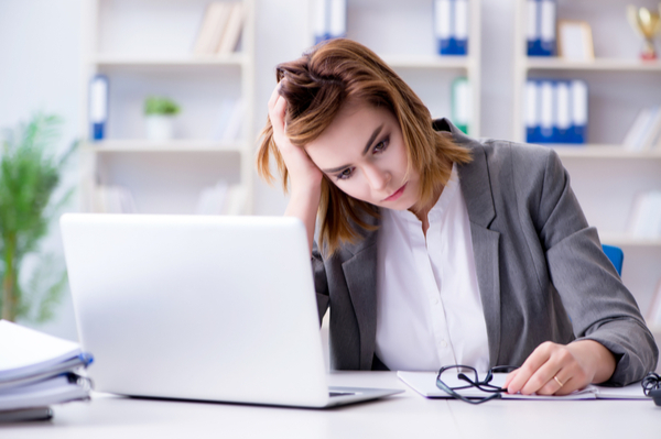 Women looking at laptop with hand on head