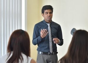 Man standing in front of an audience, giving a talk