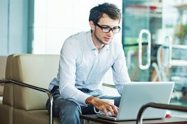 A man writing something on his laptop