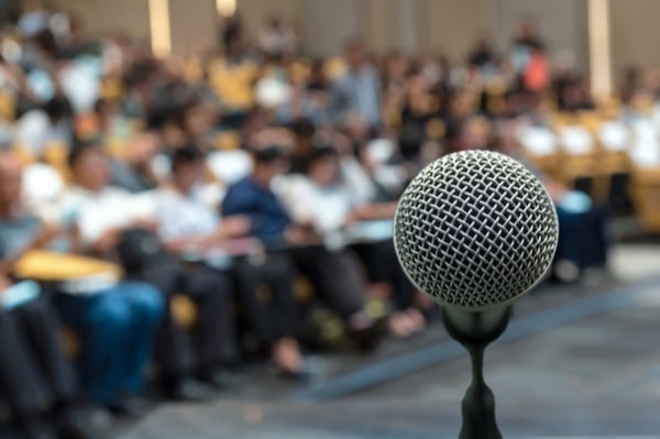 Microphone and audience in the background