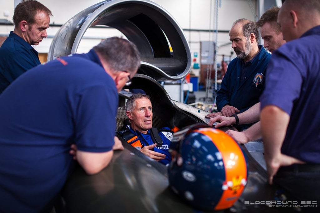mechanics talking to driver in cockpit