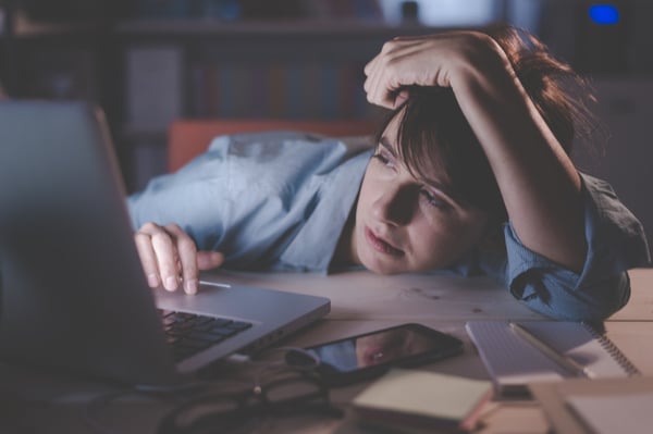 A woman lying on the desk in front of computer