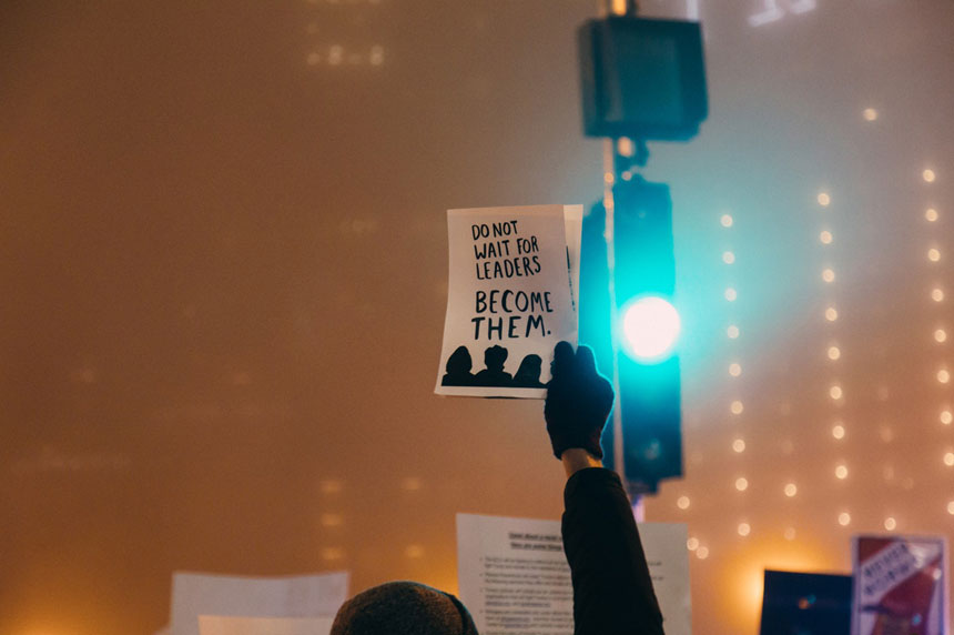 man holding paper with slogan
