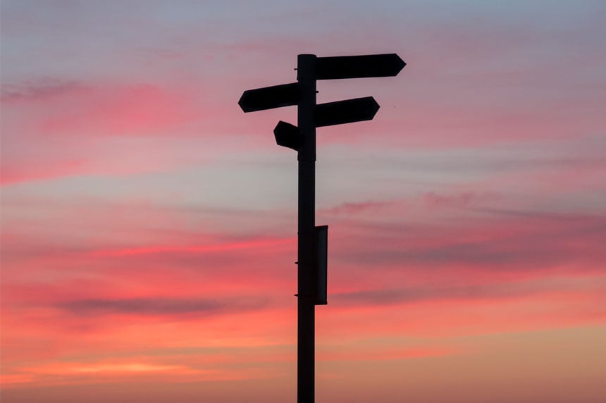 Signpost in front of sunset