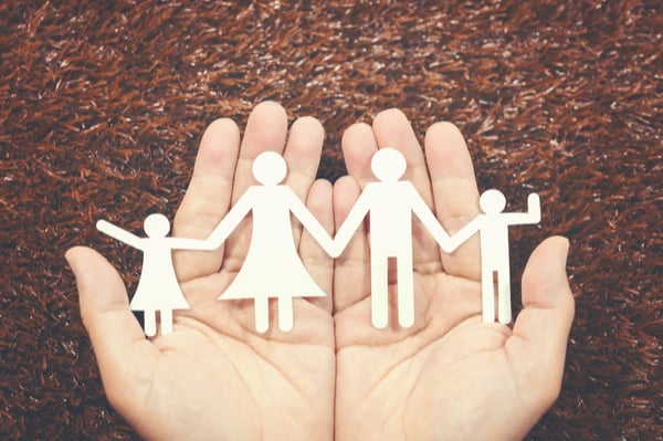 hands holding a paper family