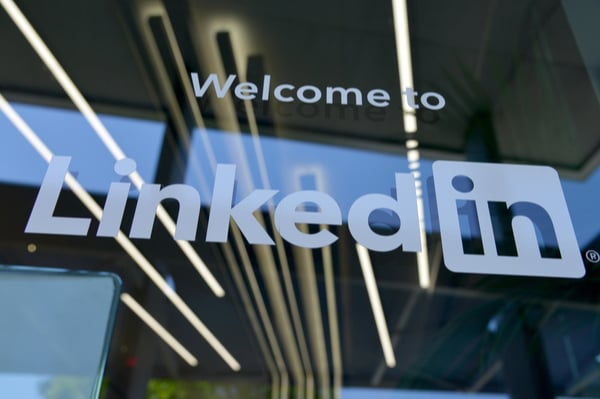 LinkedIn logo in white on a glass window