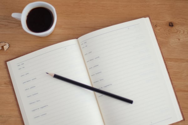 Cup of coffee, book and pen on a desk