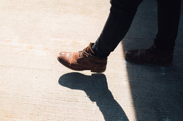 a person's legs taking a step from the shade to sunlight