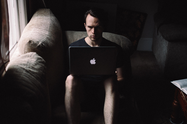 Person sitting on a coach having laptop in his lap