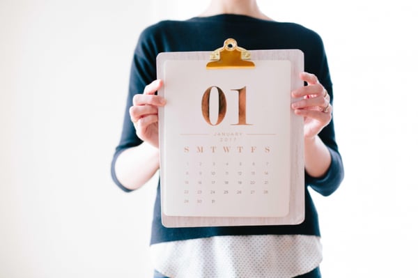 a woman holding a calendar on a clipboard which shows 01 January 2017