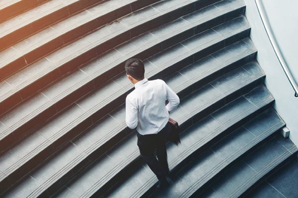 Man carrying a briefcase climbing a flight of stairs