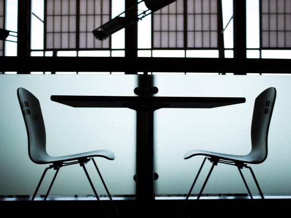 Two empty chairs across a table