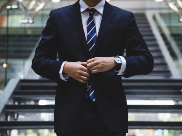 Person doing up suit buttons