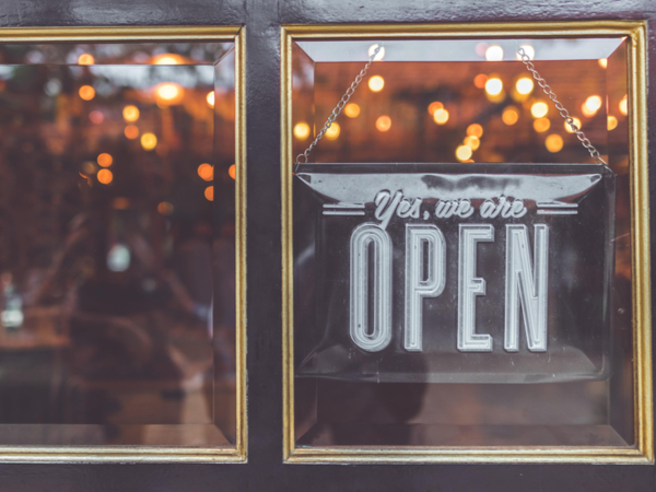 Sign on shop door reading "Come in, we're open!"