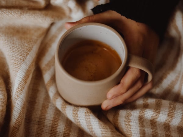 Hand cradling a cup of coffee