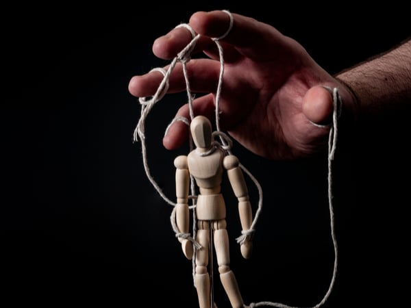 Hands controlling marionette puppet