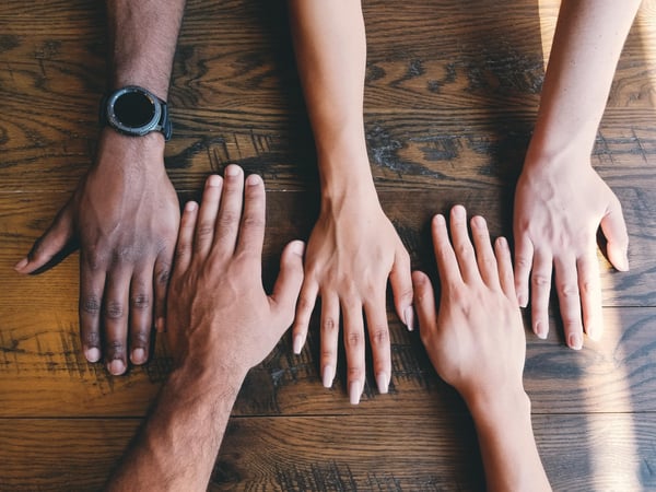 Hands of different ethnicities on a table