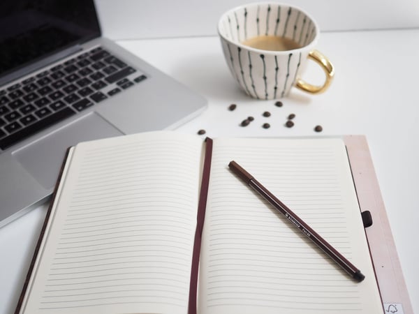 Organised notebook and tea beside a laptop