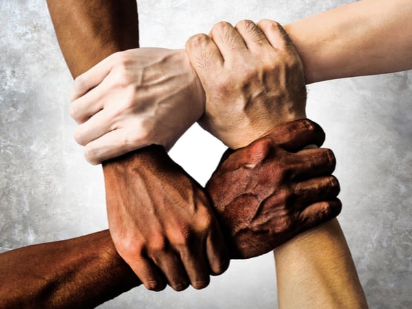 Hands of different ethnicities in a square