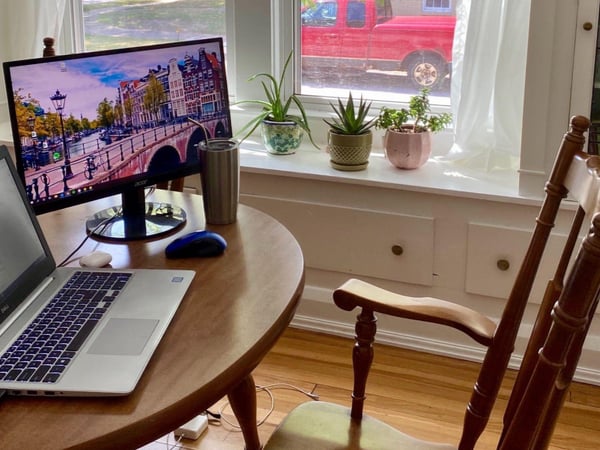 Laptop and screen on table in a home