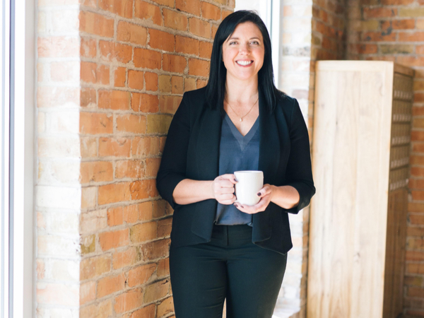 Woman holding a coffee cup and looking into camera