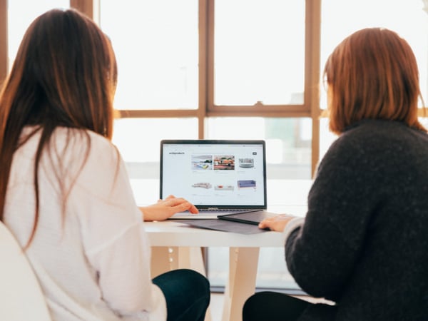 Two women beside computer