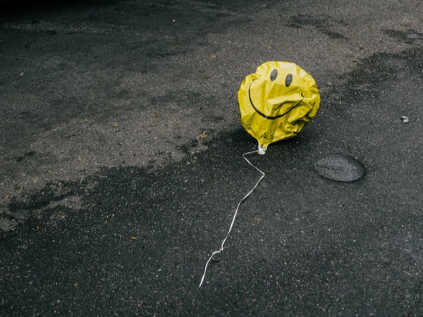 Deflating smiley-face balloon