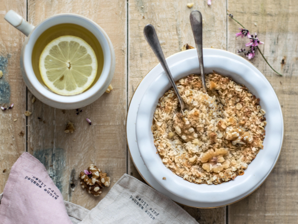 Bowl of porridge next to a cup of tea