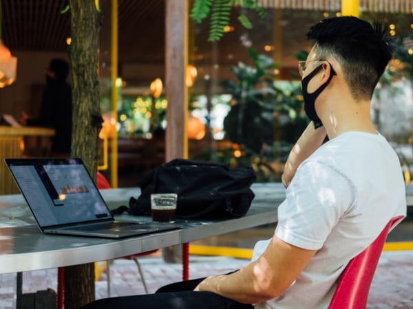 Person in mask working in an outdoor cafe