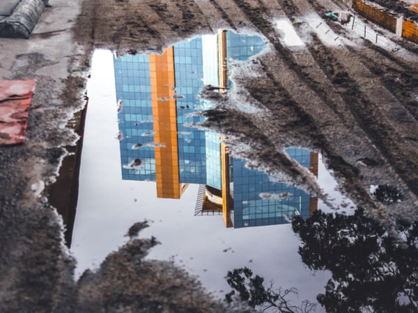 Buildings reflected in puddle