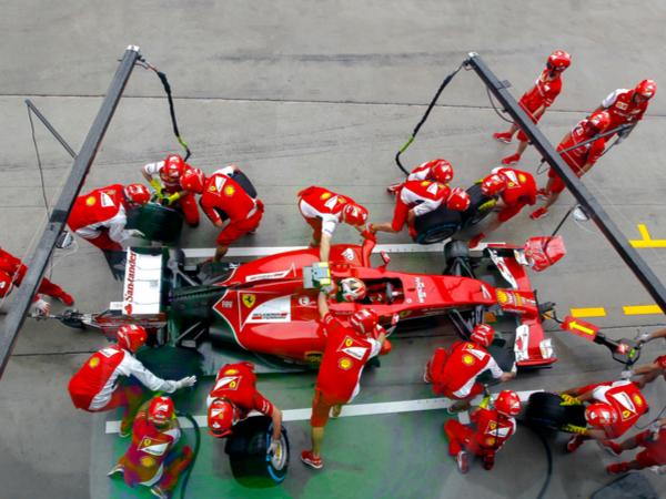 F1 team collaborating in the pit during a race