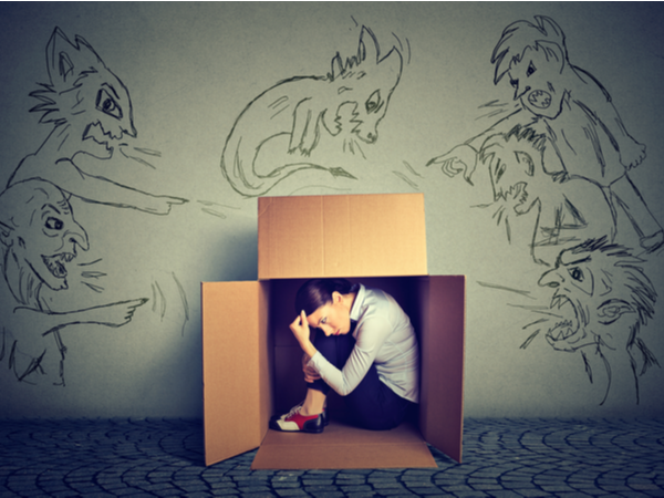 Woman hiding from inner demons in a box