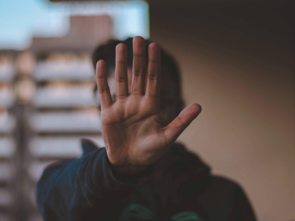 Person holding their hand up in a 'stop' gesture