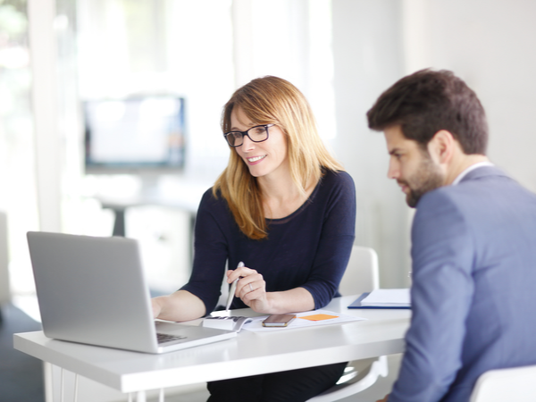 Two people working on a laptop together