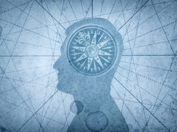 Silhouette of a head with a compass where the brain should be
