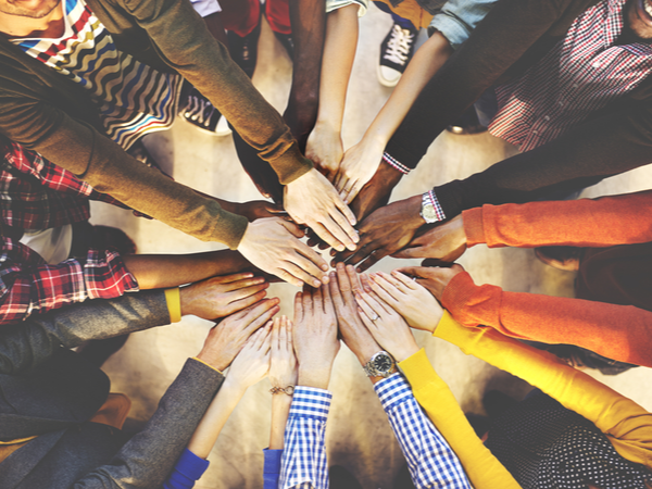 Hands of colleagues stacked in a team huddle