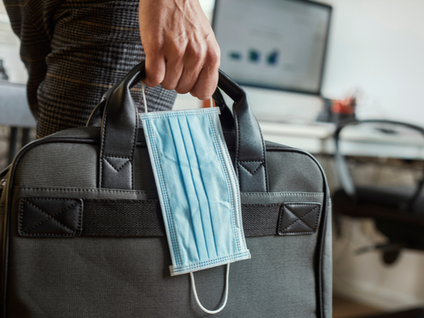 Person carrying briefcase and face mask into office